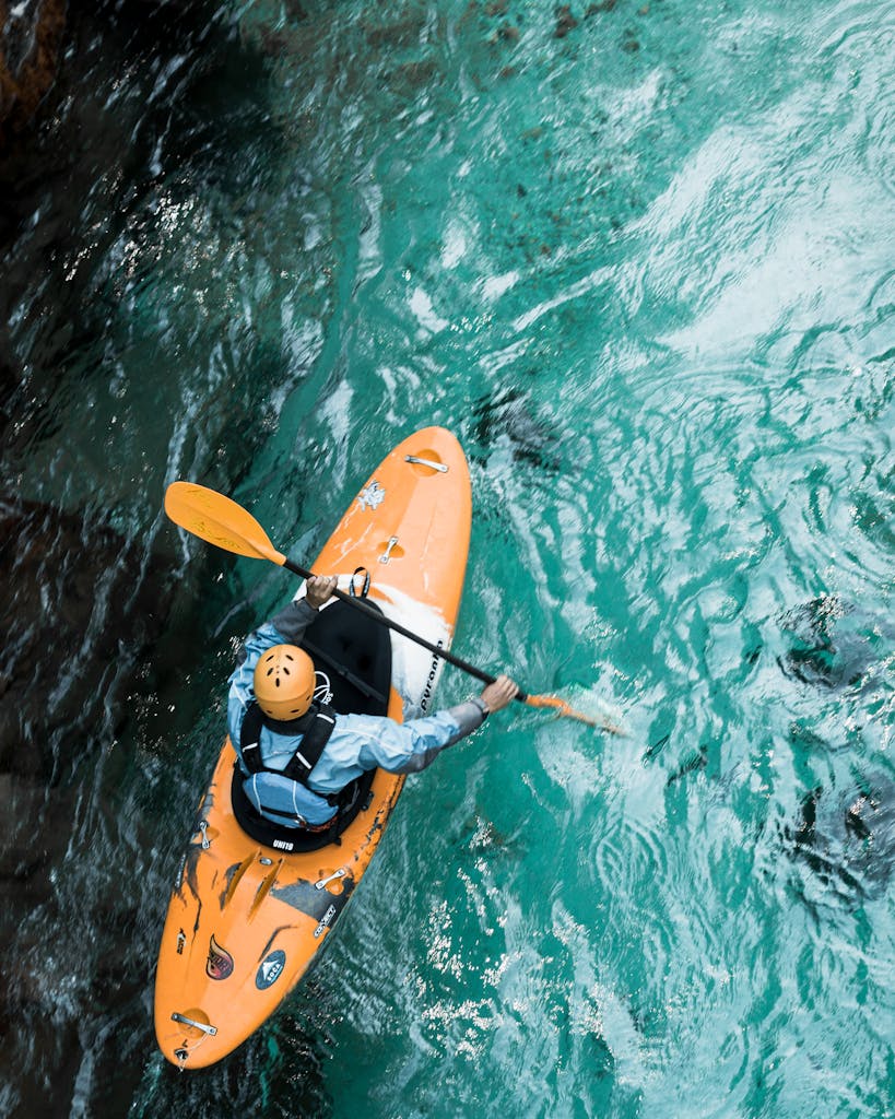A kayaker paddles through clear turquoise waters, showcasing adventure sports in Croatia.